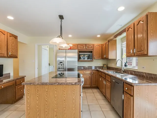 a kitchen with stainless steel appliances granite countertop a sink a stove top oven a counter space and cabinets