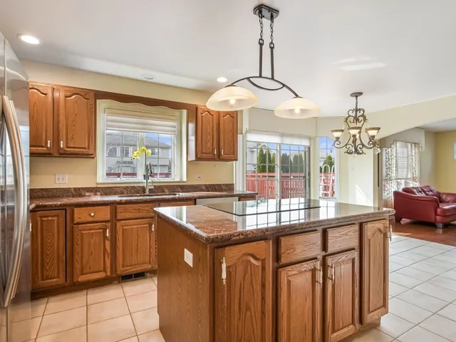 a kitchen with stainless steel appliances granite countertop a stove a sink dishwasher and a wooden cabinets