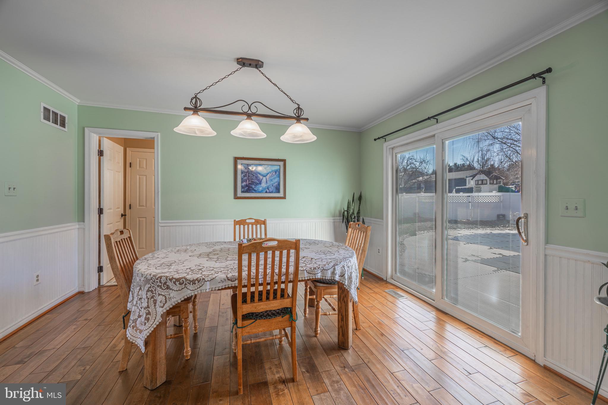 716 Paradise Road Aberdeen, MD 21001 - Photo 39 of 85 a dining room with wooden floor a chandelier a wooden table and chairs