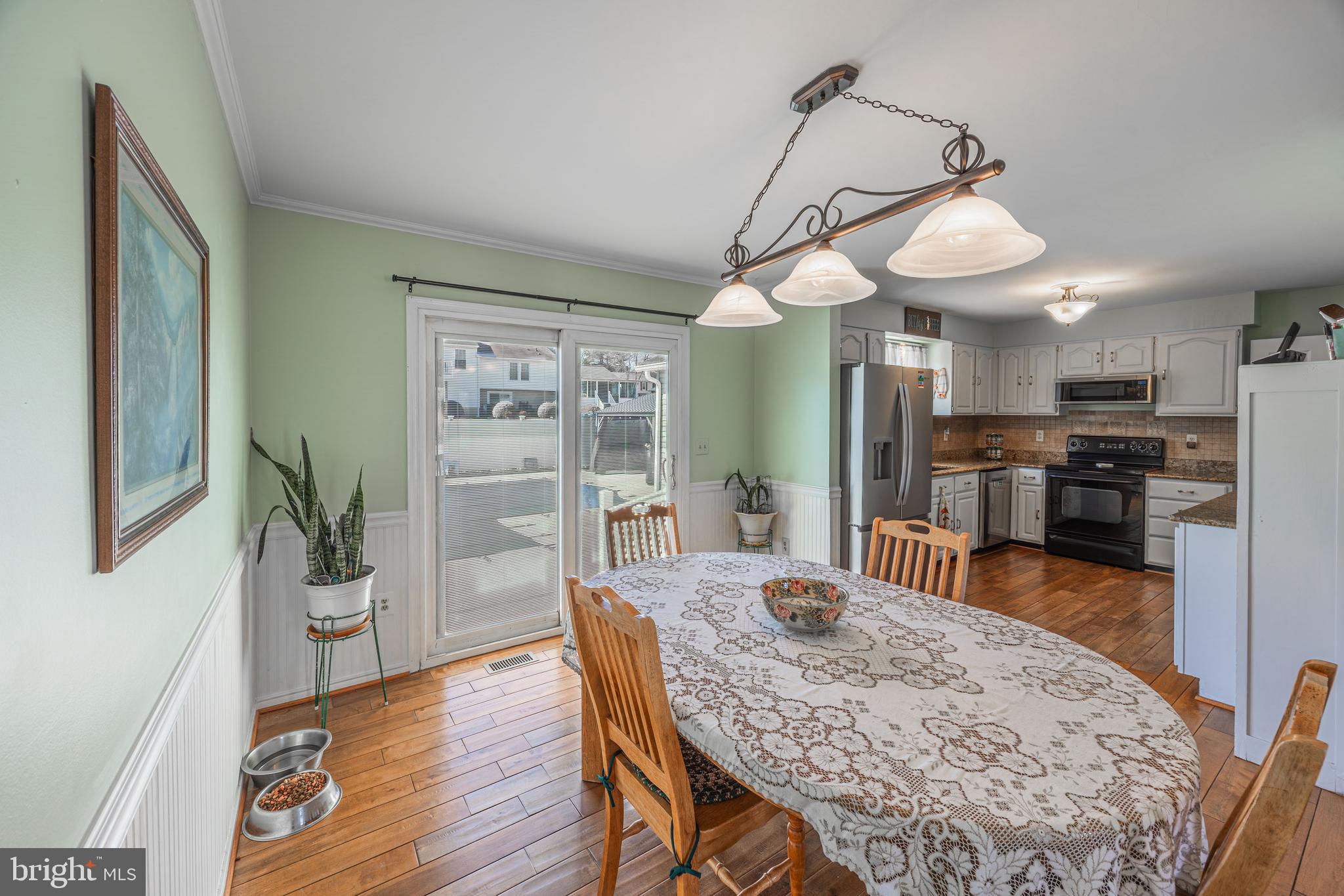 716 Paradise Road Aberdeen, MD 21001 - Photo 40 of 85 a dining room with wooden floor a chandelier a wooden table and chairs