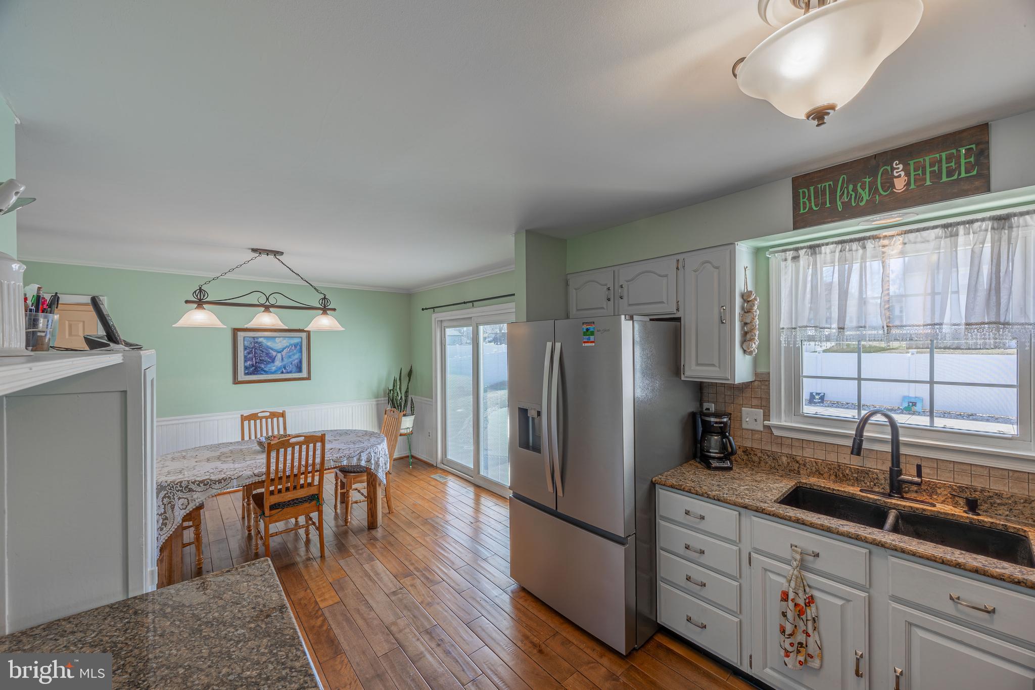 716 Paradise Road Aberdeen, MD 21001 - Photo 50 of 85 a kitchen with stainless steel appliances granite countertop a refrigerator a sink dishwasher a dining table and chairs with wooden floor