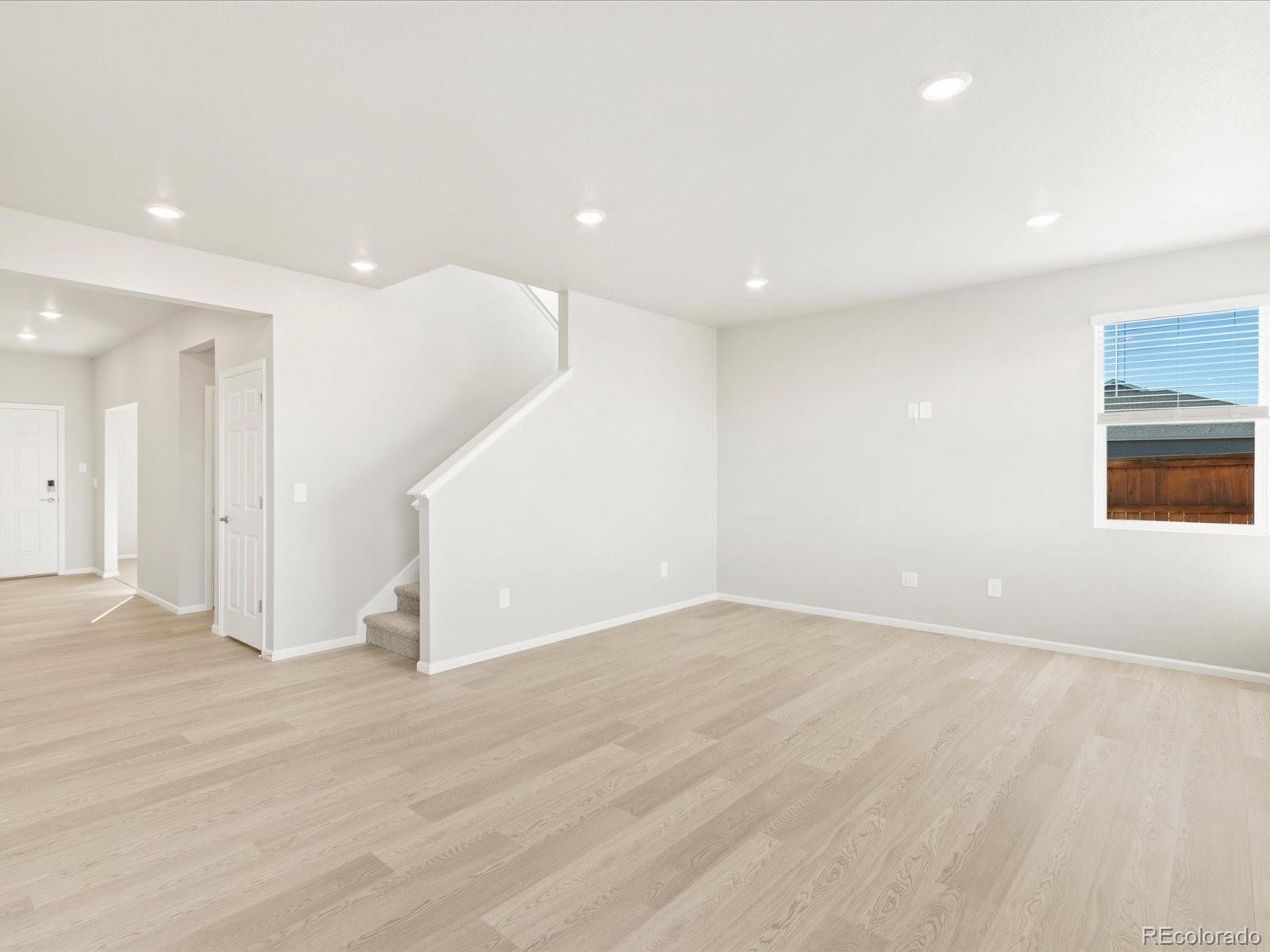 851 Frst Cyn Road Severance, CO 80550 - Photo 11 of 37 an empty room with wooden floor and windows