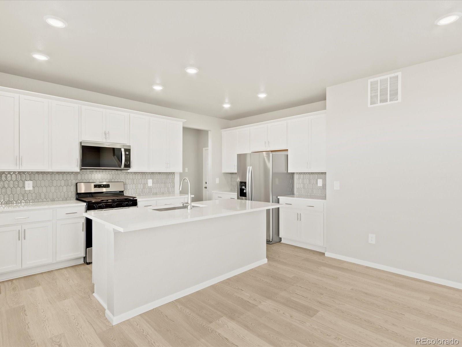 851 Frst Cyn Road Severance, CO 80550 - Photo 12 of 37 a kitchen with stainless steel appliances a refrigerator stove a sink and white cabinets
