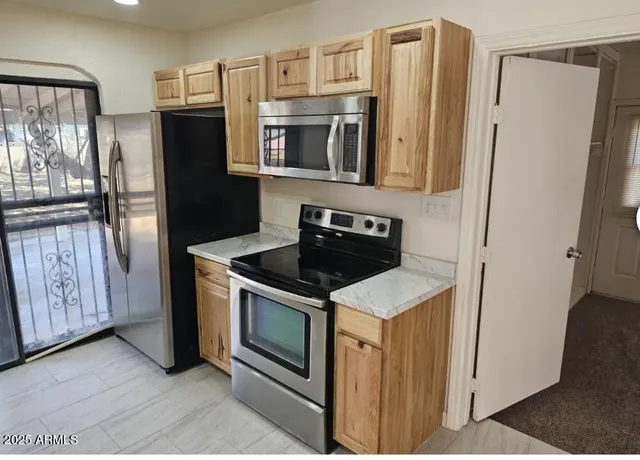 a kitchen with stainless steel appliances granite countertop a refrigerator and a stove