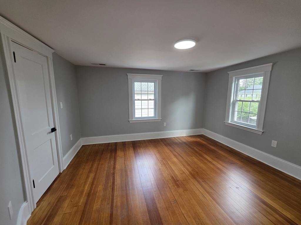 61 Poplar Street Danvers, MA 01923 - Photo 14 of 18 an empty room with wooden floor and windows
