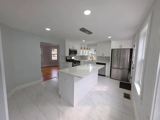 a kitchen with stainless steel appliances granite countertop a refrigerator and a stove top oven