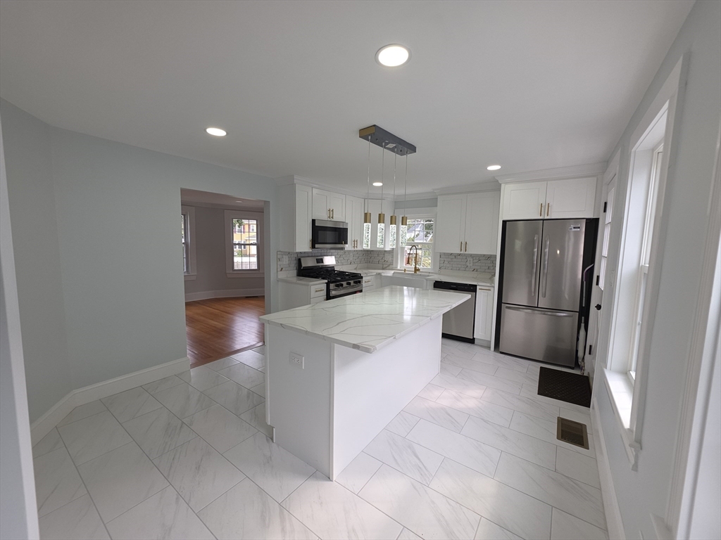 61 Poplar Street Danvers, MA 01923 - Photo 2 of 18 a kitchen with stainless steel appliances granite countertop a refrigerator and a stove top oven