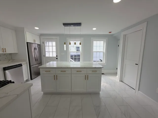 a bathroom with a granite countertop sink a toilet a mirror and a bathtub