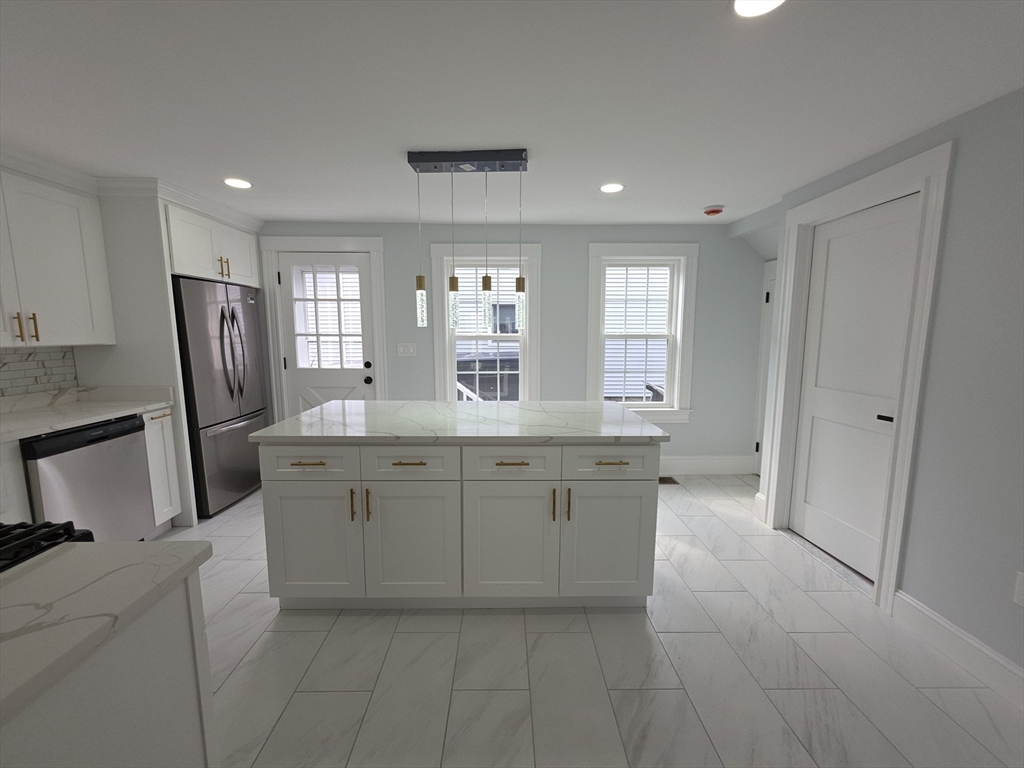 61 Poplar Street Danvers, MA 01923 - Photo 3 of 18 a bathroom with a granite countertop sink a toilet a mirror and a bathtub