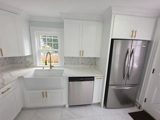 a kitchen with white cabinets and refrigerator