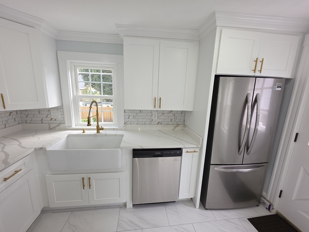 61 Poplar Street Danvers, MA 01923 - Photo 4 of 18 a kitchen with white cabinets and refrigerator