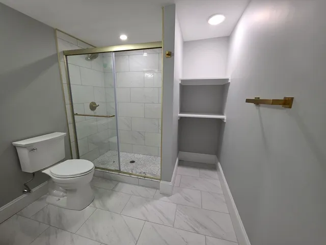 a bathroom with a toilet and a shower