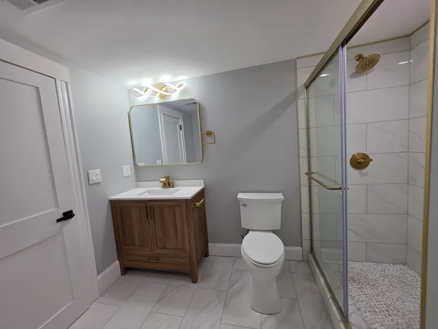 a bathroom with a sink a toilet and shower