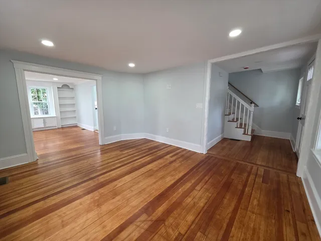 a view of an empty room with wooden floor