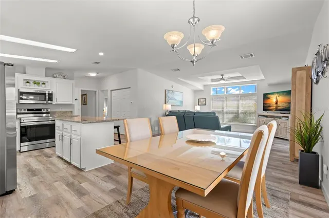a view of kitchen with refrigerator stove dining table and chairs