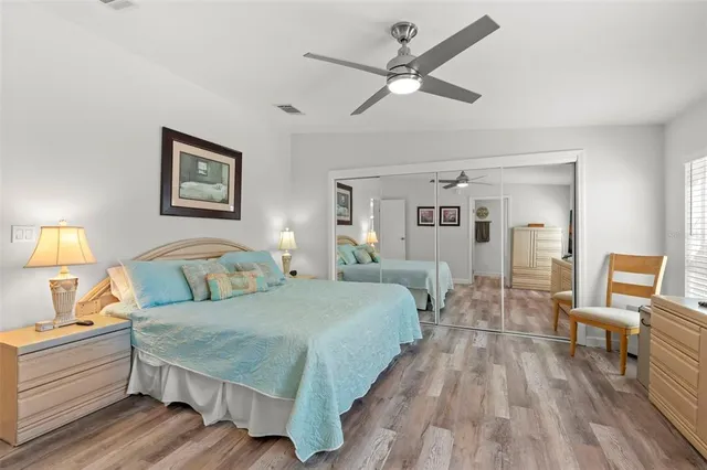 a spacious bedroom with a bed and wooden floor