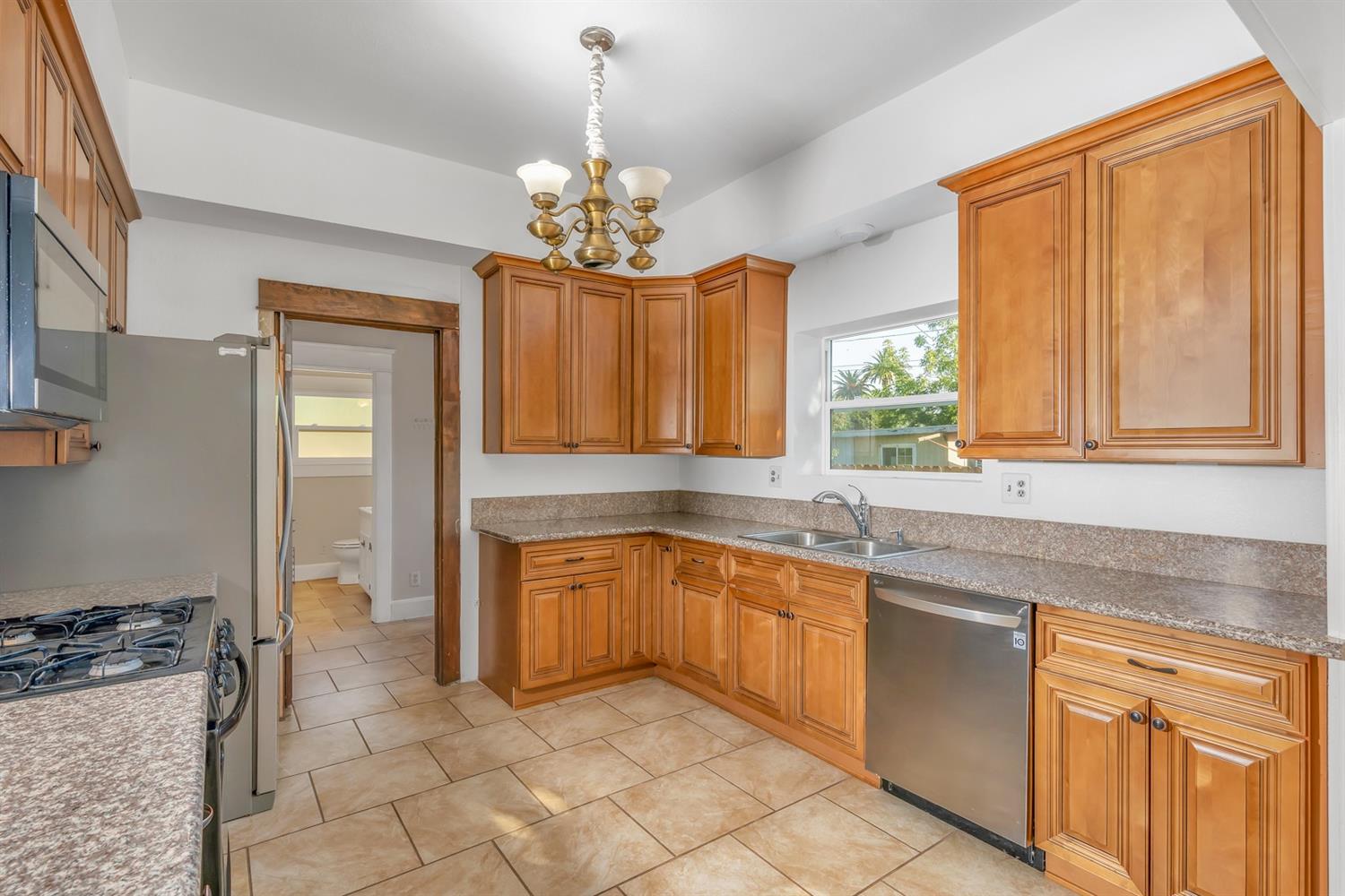 1158 K Street Reedley, CA 93654 - Photo 8 of 31 a kitchen with stainless steel appliances granite countertop a sink and cabinets