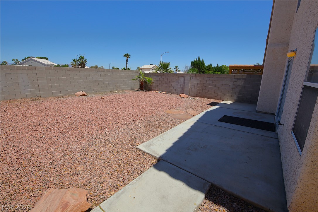 8220 Maplestar Road Las Vegas, NV 89128 - Photo 27 of 29 A low-maintenance yard features concrete paving, a block wall, and decorative rock landscaping.