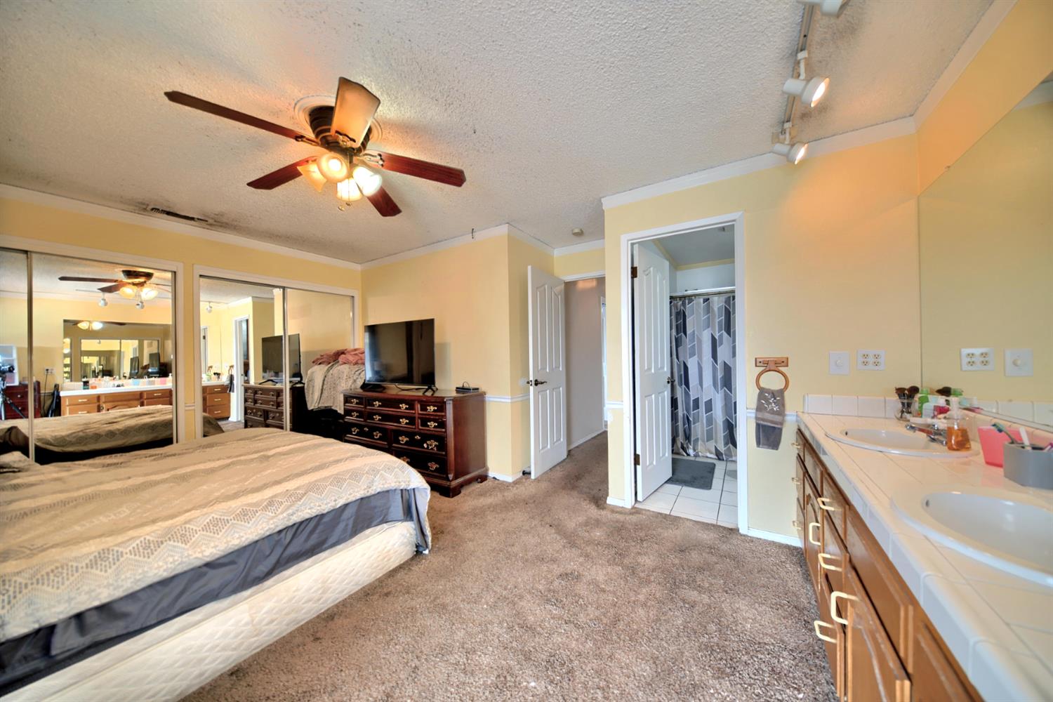 6521 Narcisco Way Hughson, CA 95326 - Photo 27 of 40 a bedroom with a bed a flat screen tv and a chandelier