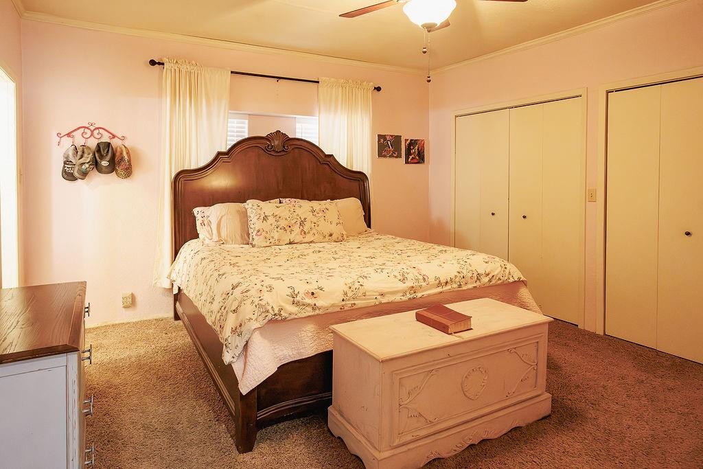 1308 West 14th Street Cisco, TX 76437 - Photo 11 of 39 a bedroom with a bed and a chandelier