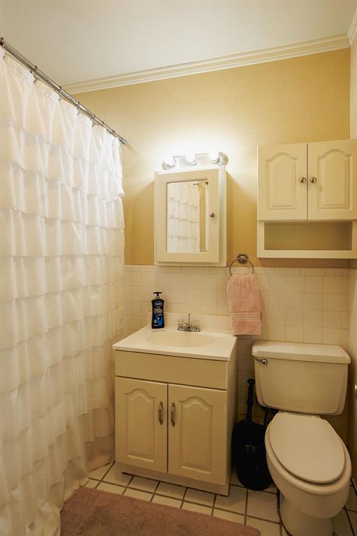 1308 West 14th Street Cisco, TX 76437 - Photo 13 of 39 a bathroom with a sink a toilet and a mirror