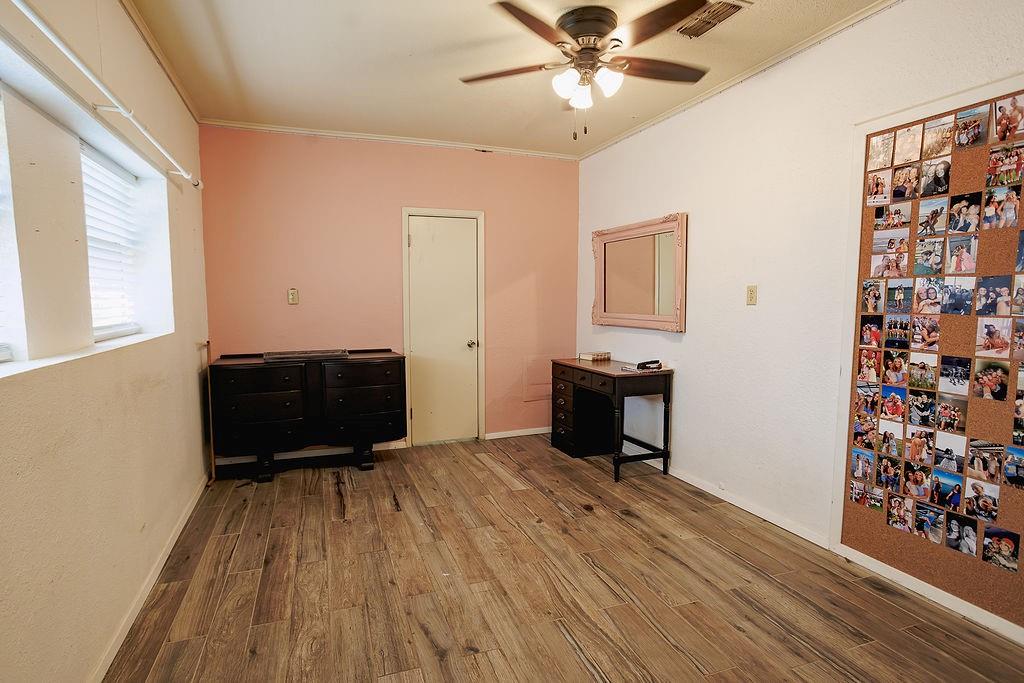 1308 West 14th Street Cisco, TX 76437 - Photo 14 of 39 a living room with hard wood floors and a ceiling fan