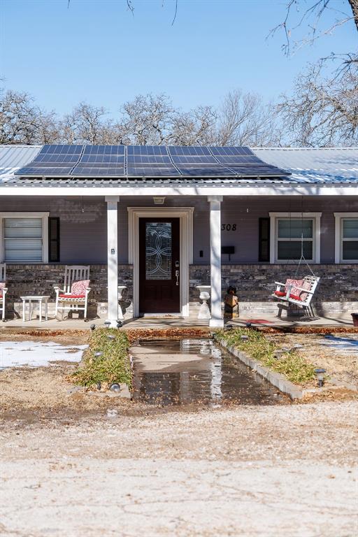 1308 West 14th Street Cisco, TX 76437 - Photo 2 of 39 a view of a patio with dining table and chairs under an umbrella next to a road