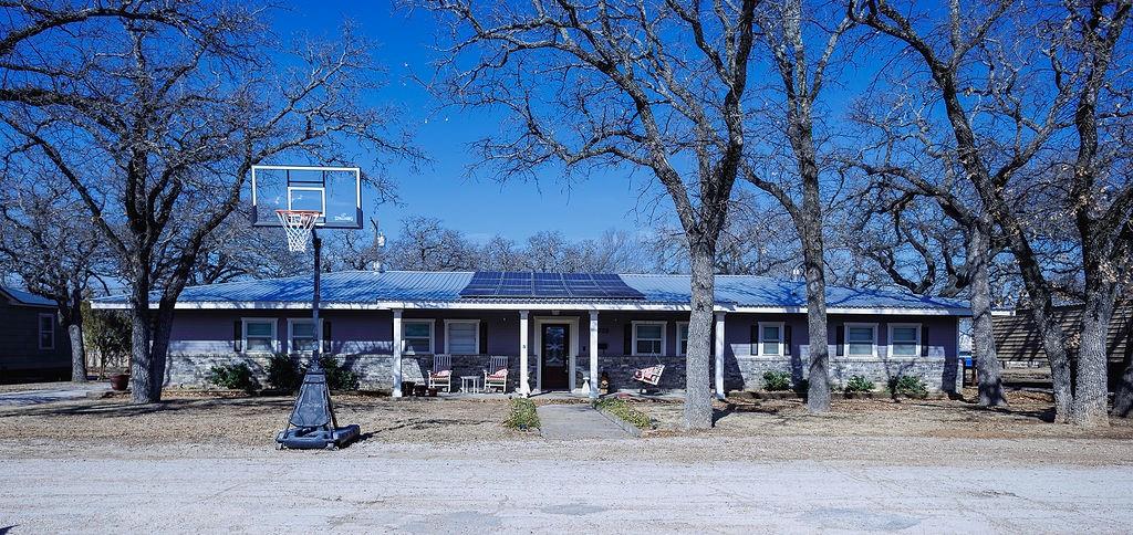 1308 West 14th Street Cisco, TX 76437 - Photo 23 of 39 a front view of a building with sitting area and covered with trees