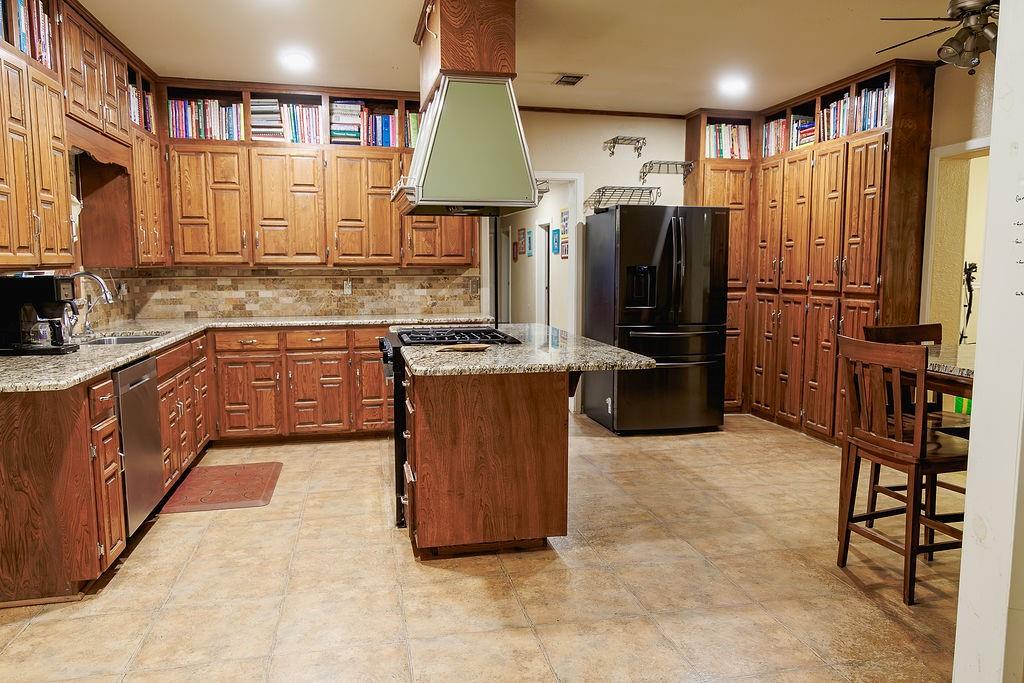 1308 West 14th Street Cisco, TX 76437 - Photo 6 of 39 a kitchen with stainless steel appliances granite countertop a sink stove and refrigerator