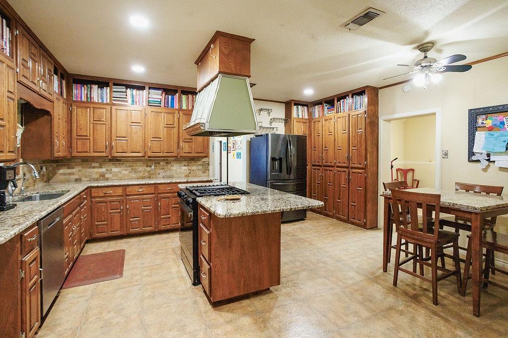 1308 West 14th Street Cisco, TX 76437 - Photo 7 of 39 a kitchen with stainless steel appliances granite countertop a stove and a refrigerator