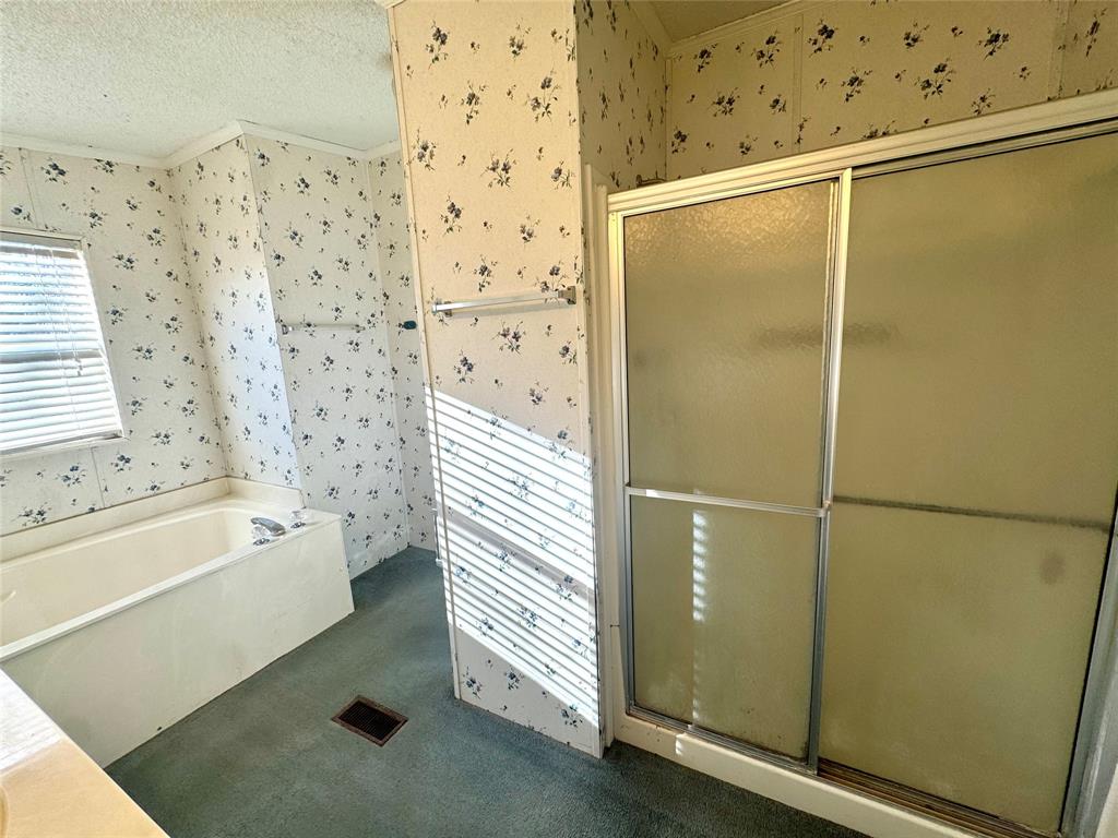 211 West F Street Munday, TX 76371 - Photo 13 of 27 a bathroom with a bathtub and a shower