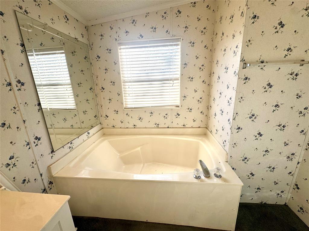 211 West F Street Munday, TX 76371 - Photo 14 of 27 a bathroom with a bathtub and a shower