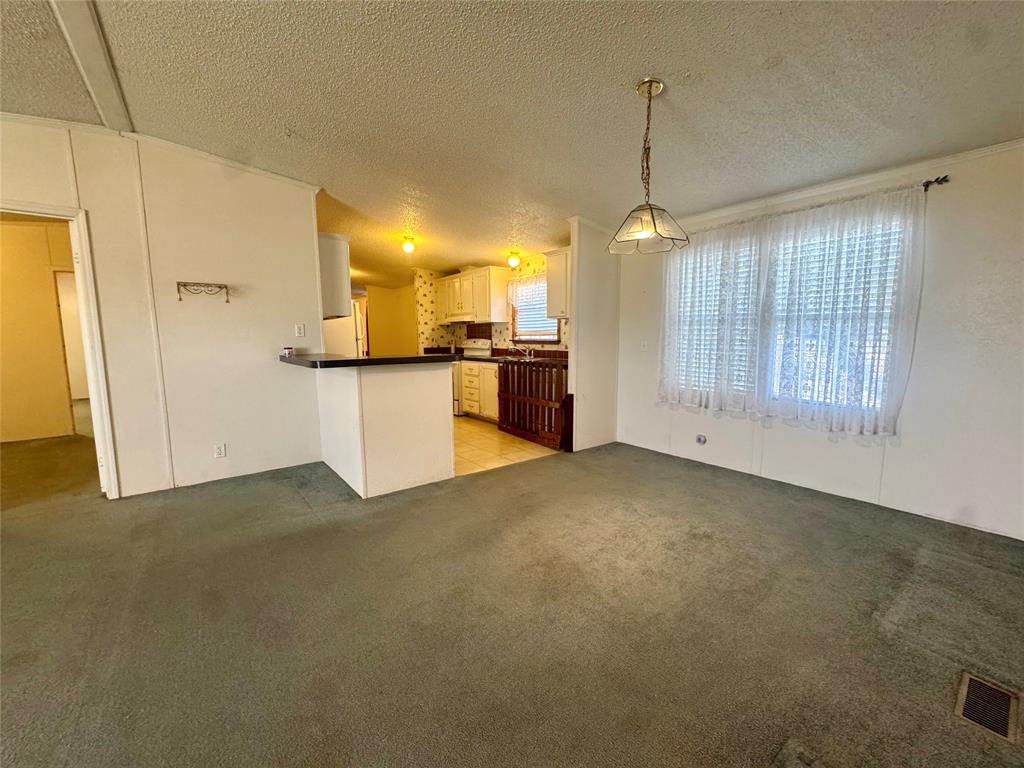 211 West F Street Munday, TX 76371 - Photo 3 of 27 a kitchen that has a lot of cabinets and stainless steel appliances