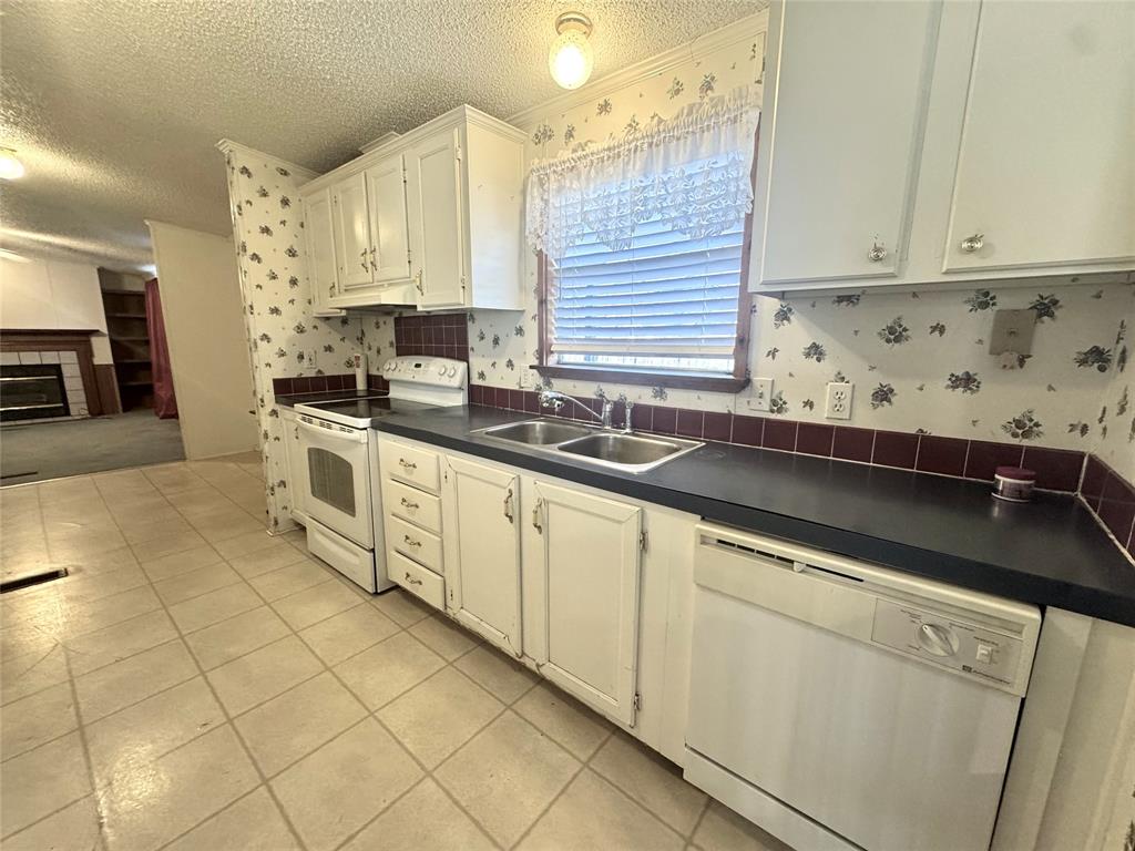211 West F Street Munday, TX 76371 - Photo 6 of 27 a kitchen with stainless steel appliances granite countertop a sink stove and cabinets