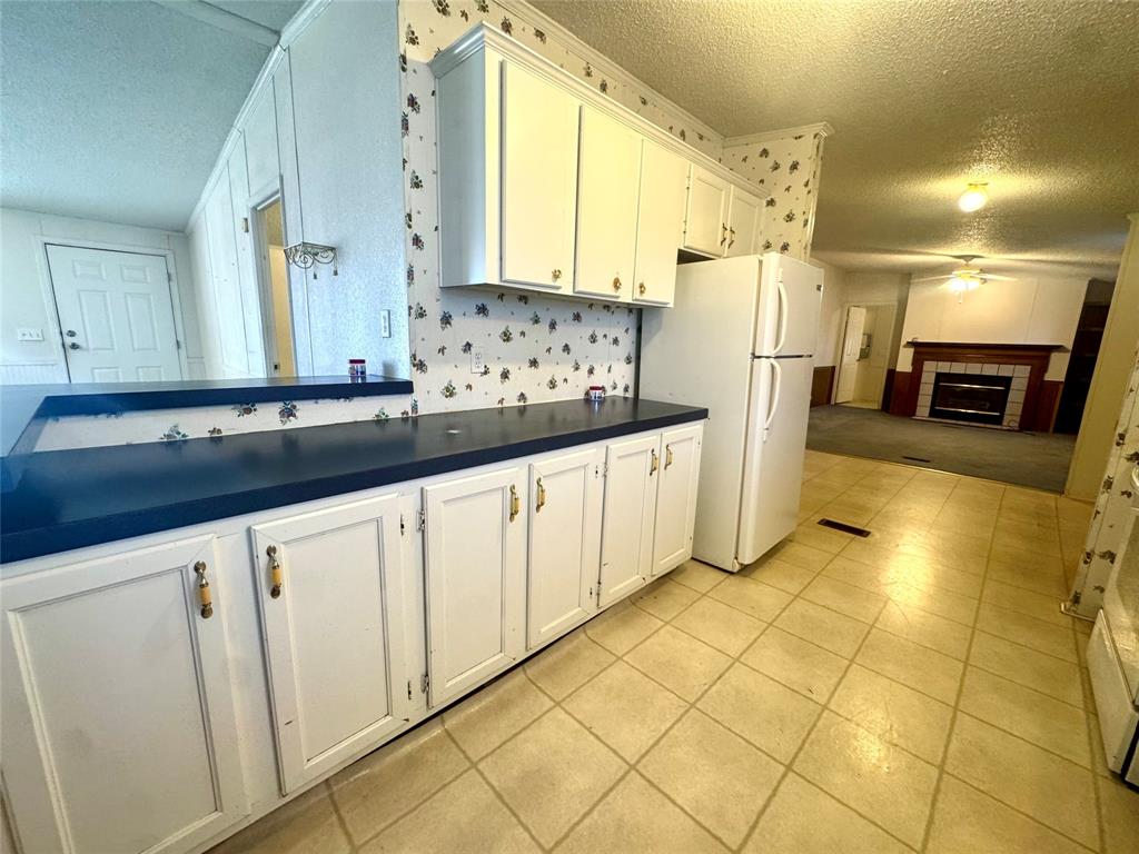 211 West F Street Munday, TX 76371 - Photo 7 of 27 a large white kitchen with stainless steel appliances a cabinets and a counter top space