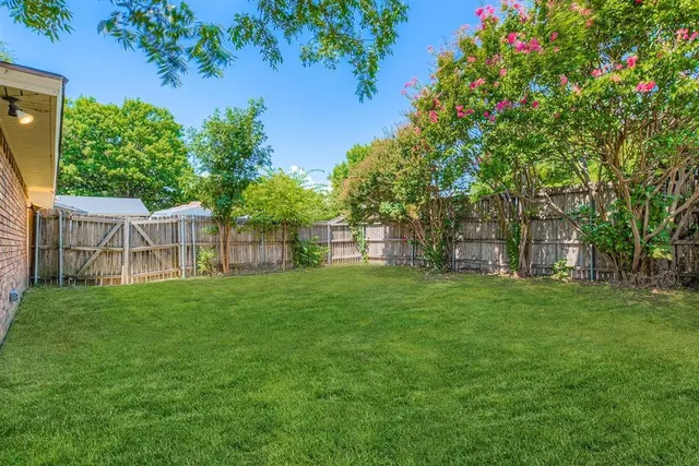 a view of a yard with a house in the background