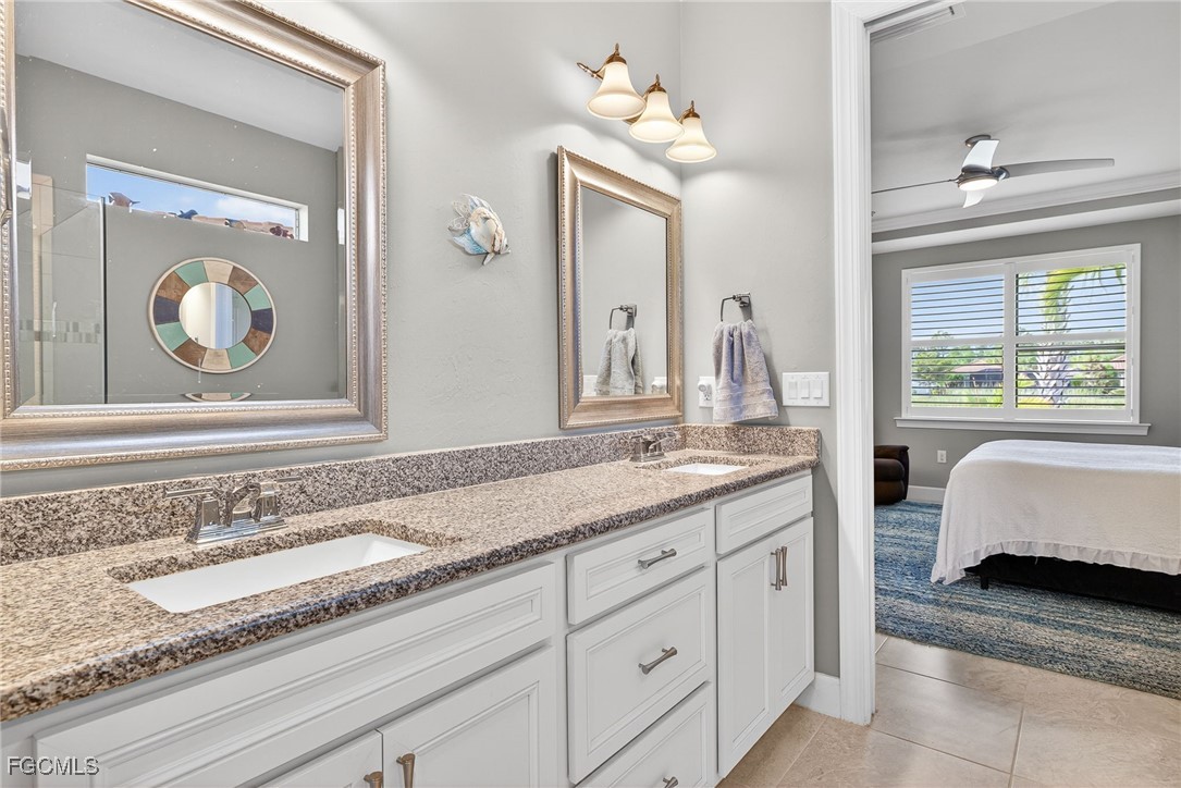 1506 Hyssop Loop North Port, FL 34289 - Photo 13 of 32 a en suite bathroom with a granite countertop sink and a mirror