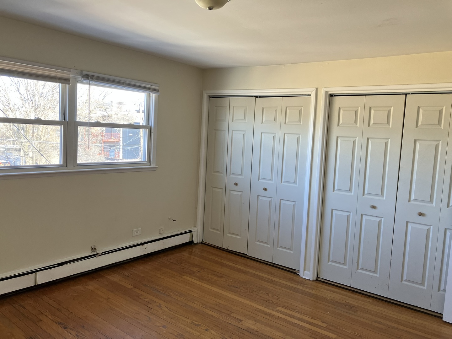 2404 East 79th Street Chicago, IL 60649 - Photo 11 of 22 an empty room with wooden floor and windows
