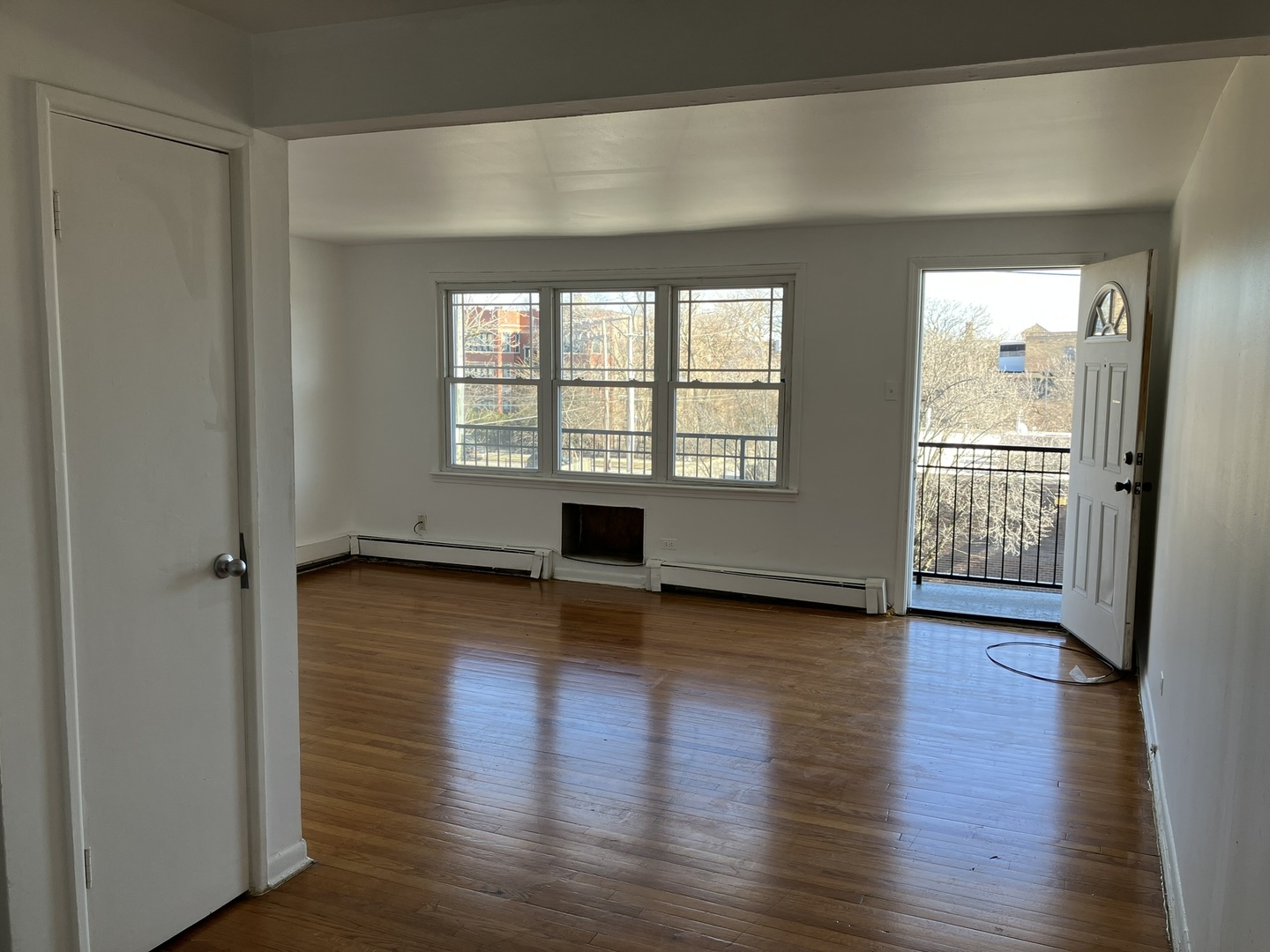 2404 East 79th Street Chicago, IL 60649 - Photo 14 of 22 an empty room with wooden floor and windows