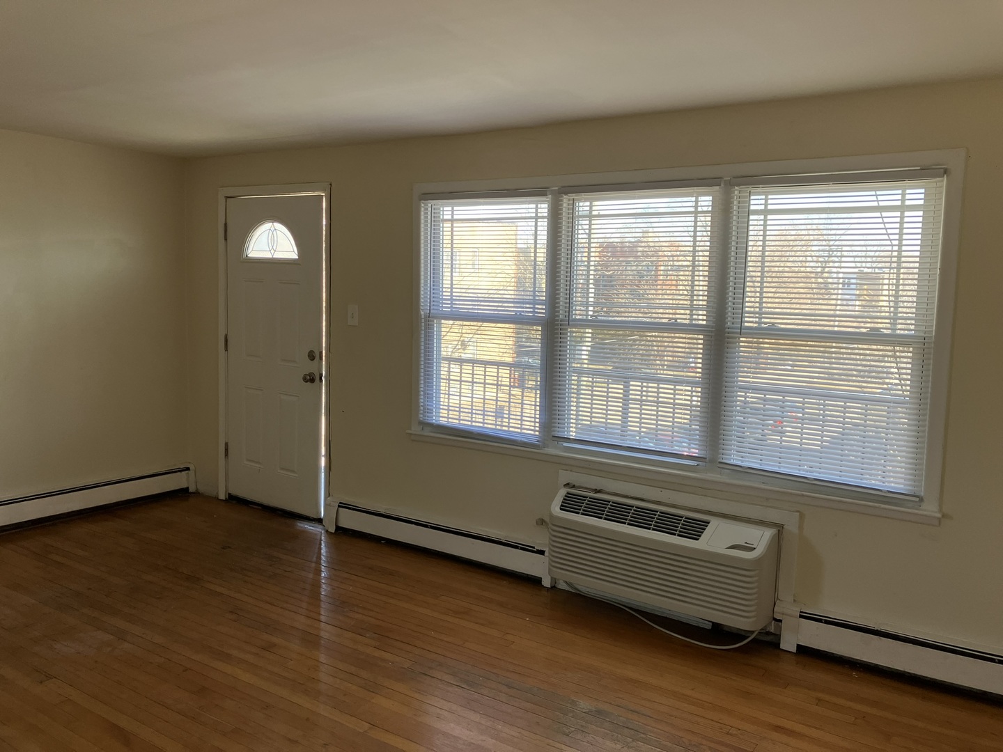 2404 East 79th Street Chicago, IL 60649 - Photo 5 of 22 an empty room with wooden floor and windows