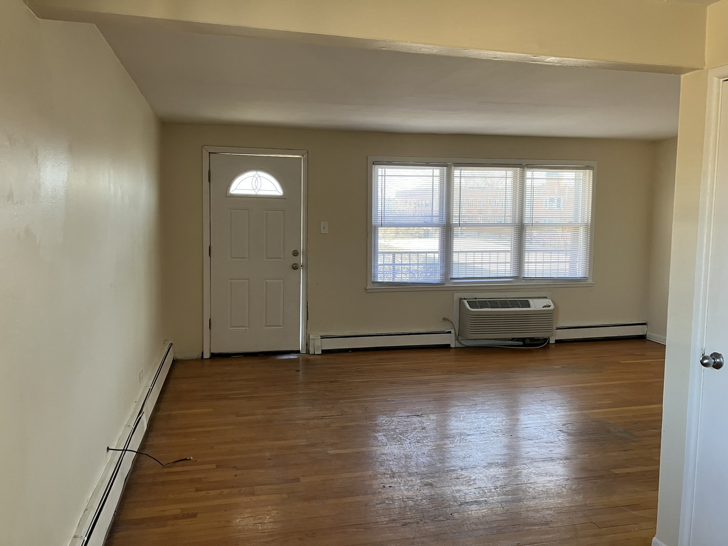 2404 East 79th Street Chicago, IL 60649 - Photo 6 of 22 an empty room with wooden floor and windows