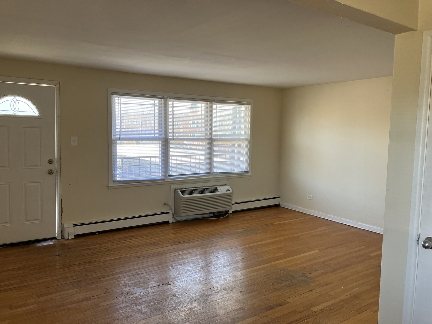 2404 East 79th Street Chicago, IL 60649 - Photo 7 of 22 an empty room with wooden floor and windows