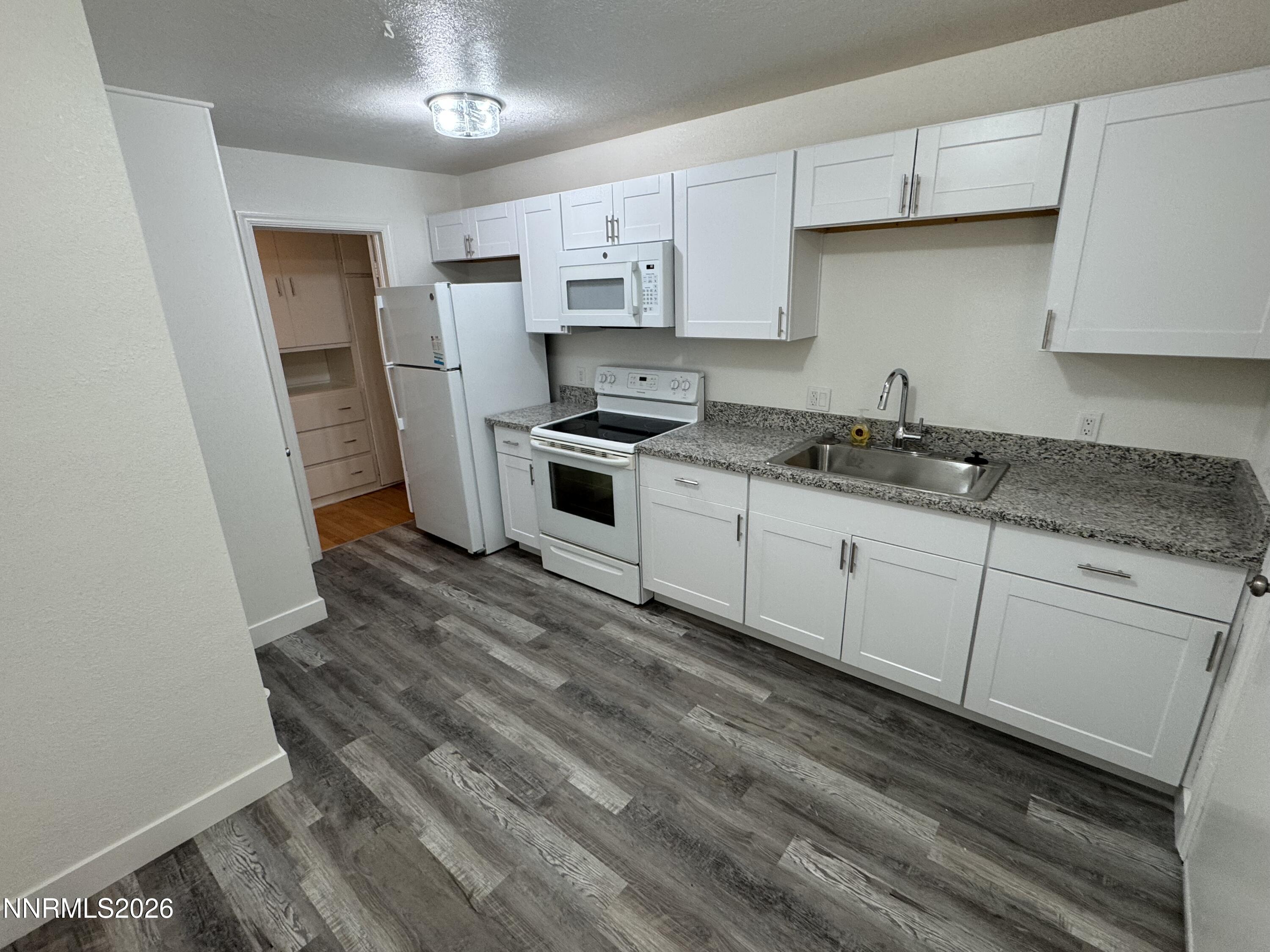 70 Arden Circle Reno, NV 89503 - Photo 3 of 15 a kitchen with granite countertop a sink stove and refrigerator