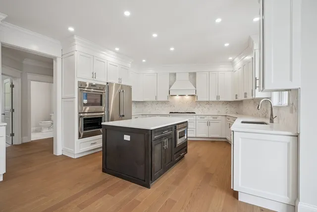 a kitchen with stainless steel appliances granite countertop a stove a refrigerator and a sink