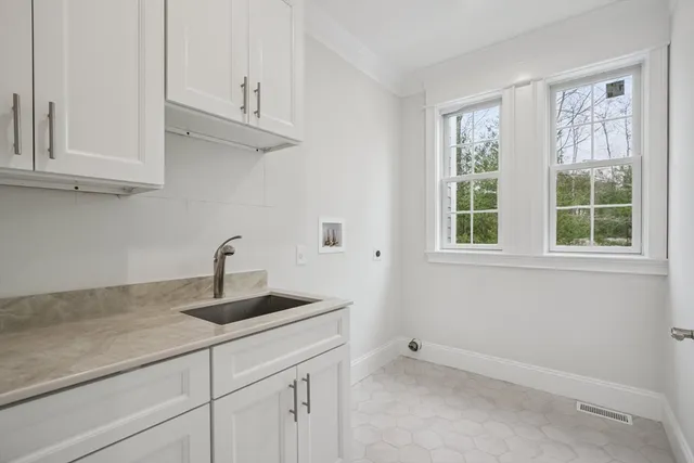 a kitchen with granite countertop white cabinets and a window