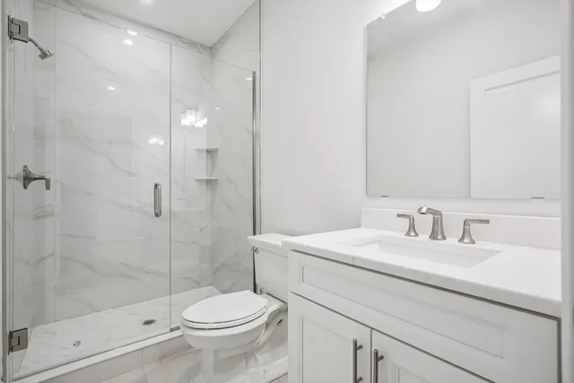 a bathroom with a sink a toilet and shower