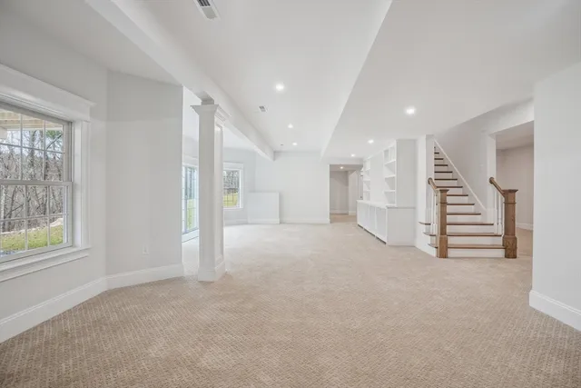 an empty room with a wooden floor and windows