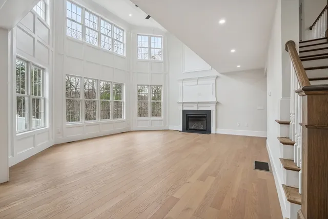 an empty room with wooden floor and fireplace