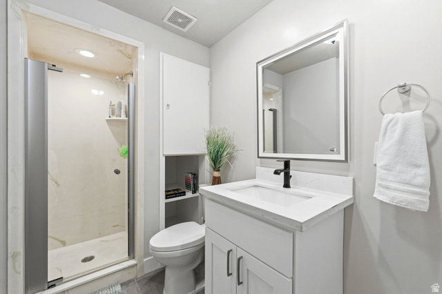 1405 Vintry Lane Murray, UT 84121 - Photo 29 of 44 Bathroom featuring a glass-enclosed shower, white vanity with integrated sink, black single-handle faucet, and mirrored cabinet