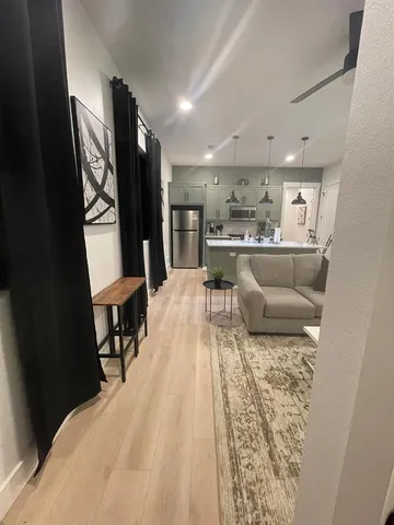 a living room with furniture wooden floor and a chandelier